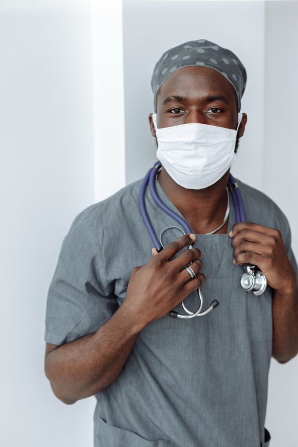 Healthcare worker wearing grey medical scrubs and a face mask