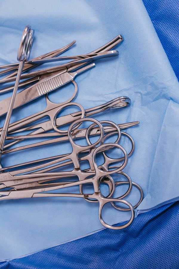 Sterile surgical instruments arranged on a blue surgical drape