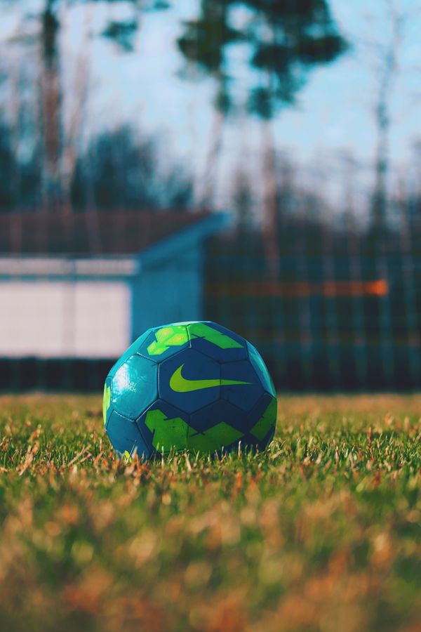 A blue and green football on a grass field